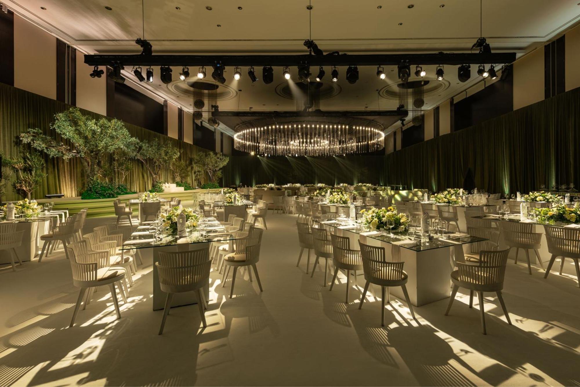 เลอ เมริเดียน ดูไบ โฮเต็ล แอนด์ คอนเฟอเรนซ์ เซ็นเตอร์ Hotel ภายนอก รูปภาพ The photo shows an elegantly designed banquet or event space. The room features several tables arranged with white tablecloths, each set with plates, glasses, and floral centerpieces. There are modern, light-colored chairs around the tables. The ambi